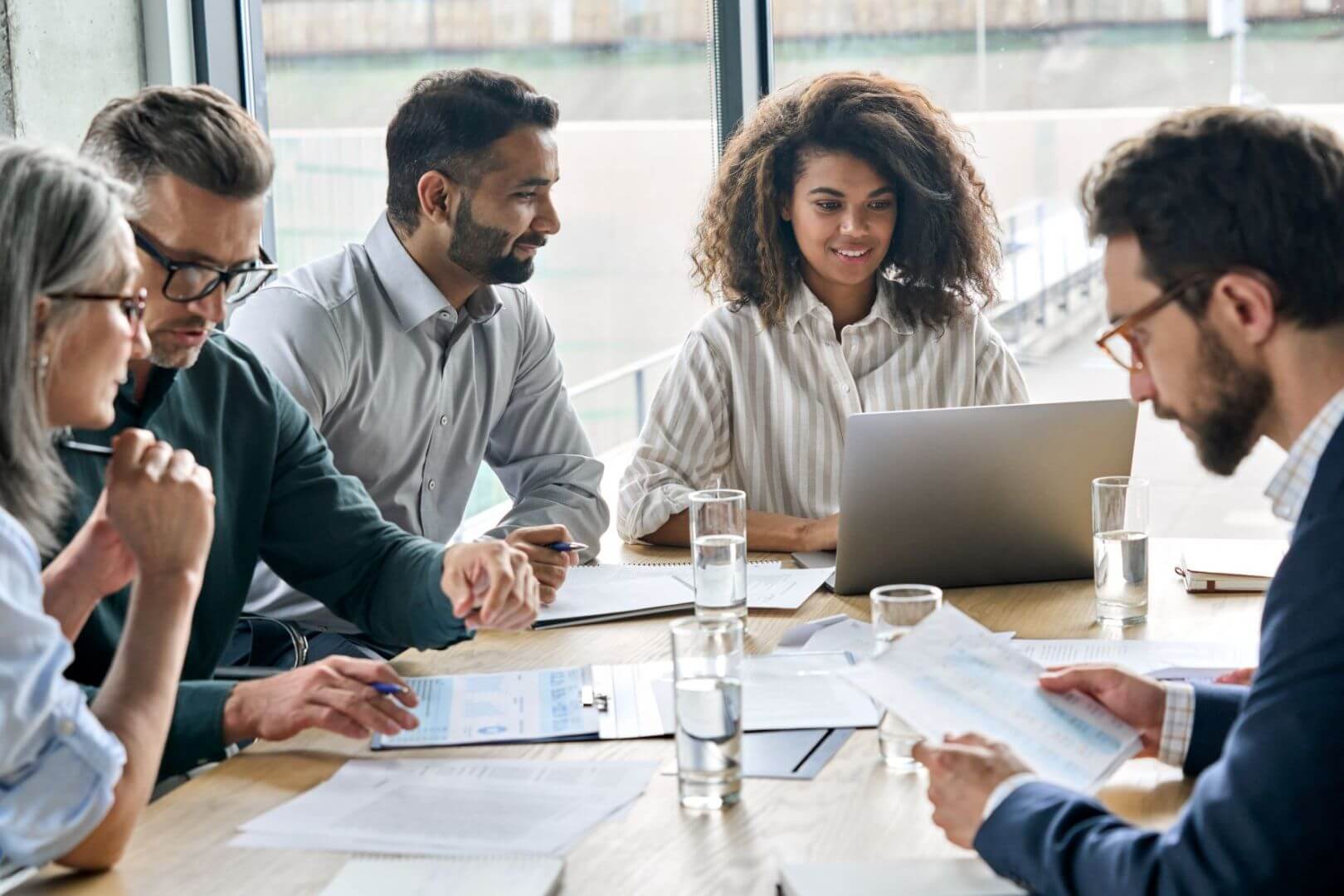 Photograph of people holding a meeting on a large desk