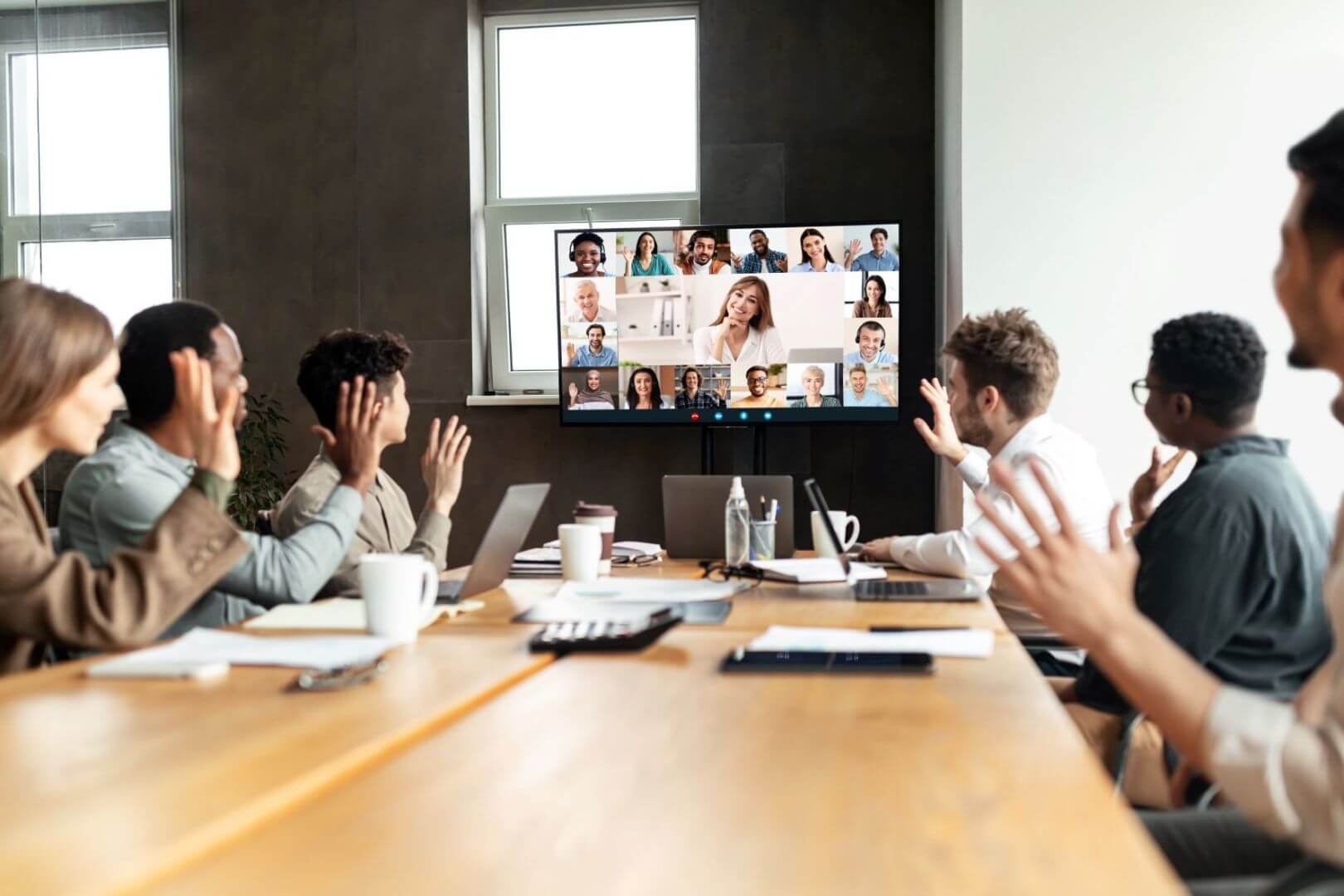 Photo of people in a large conference rooming hosting a video conference