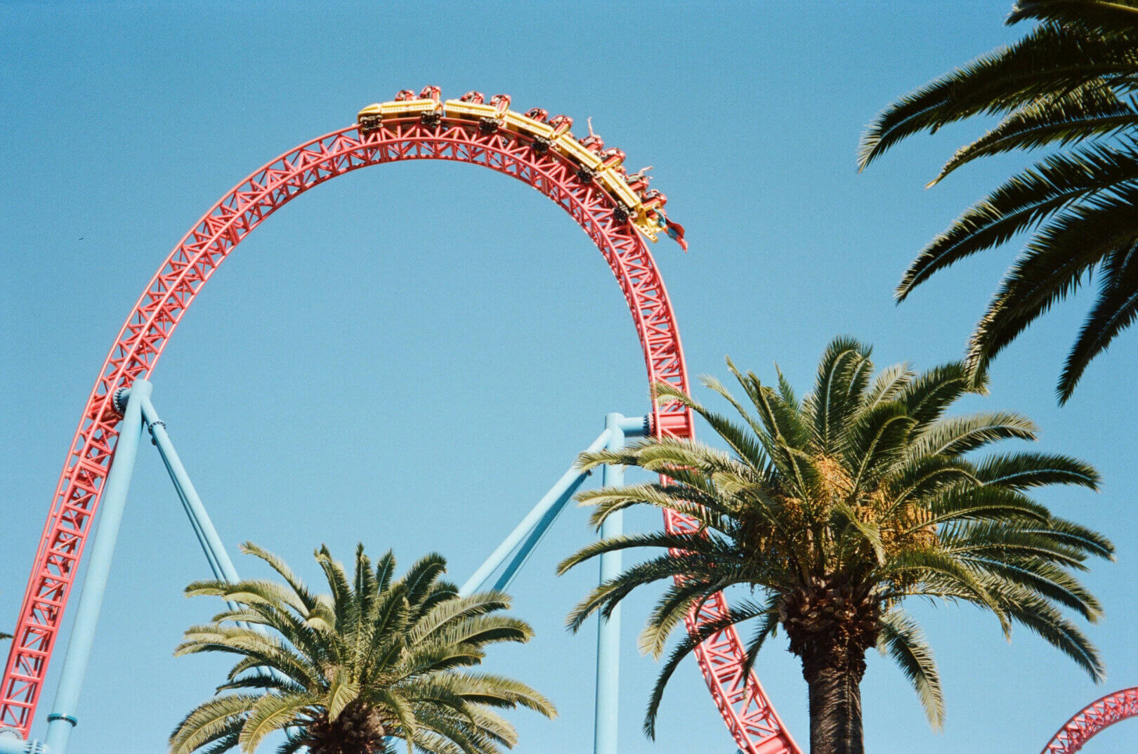 Shots of colorful attractions, park signs, and sunny SoCal skies over entertainment zones.