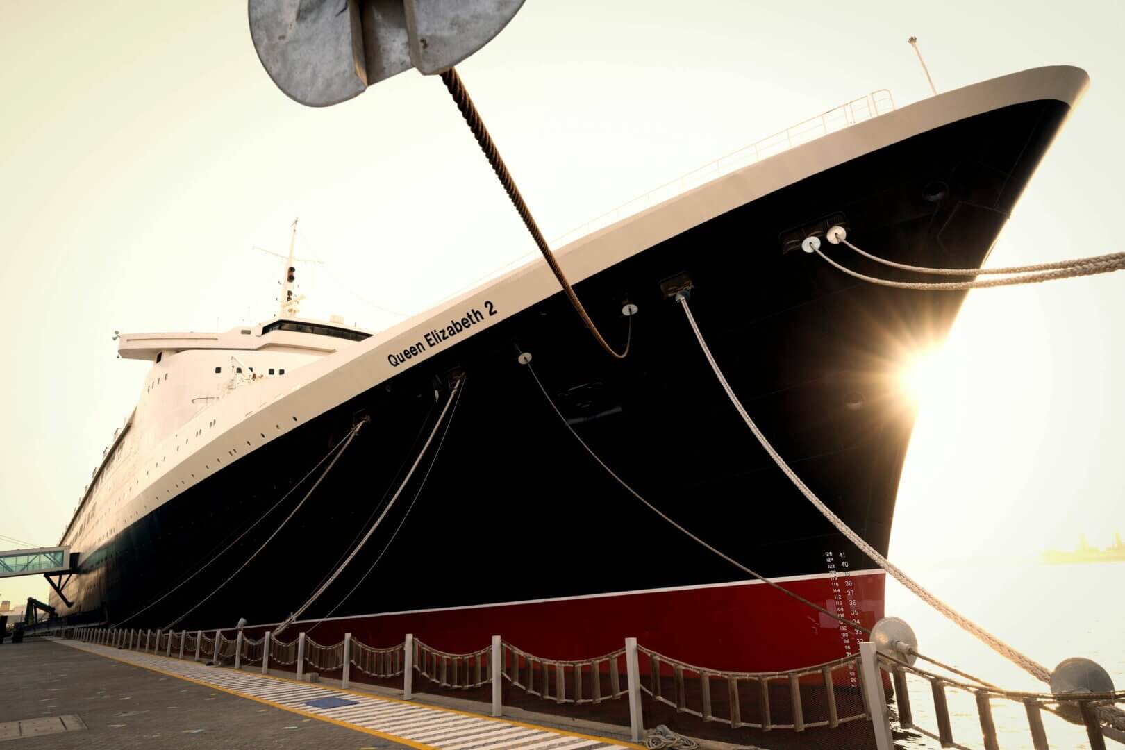 The Queen Mary in Long Beach, CA, a historic ocean liner turned museum and hotel, docked in the scenic harbor.
