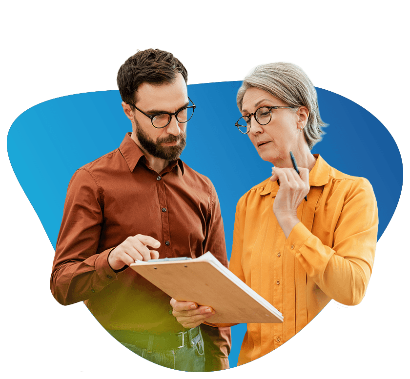 Two business professionals reviewing a consulting document together, man pointing at clipboard while colleague considers notes with a pen